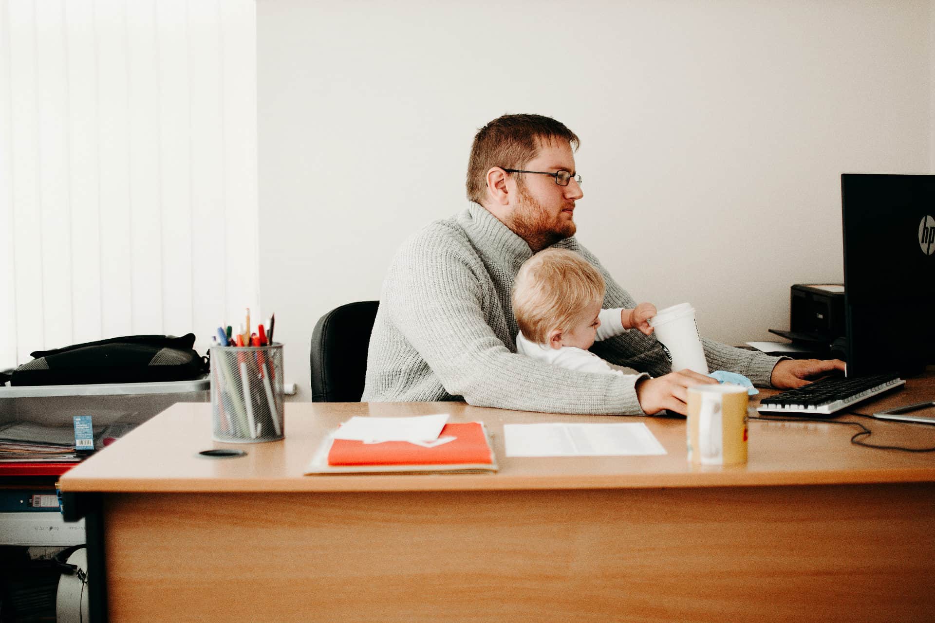 Ojciec w pracy przy komputerze z dzieckiem